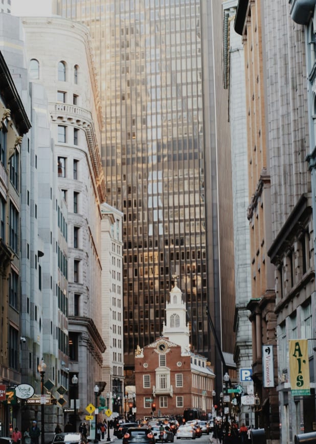 A bustling city street with cars and tall buildings in the background.